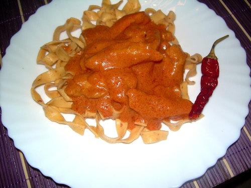 Kurczak w aksamitnym pomidorowym sosie podany na tagiatelle z chili
